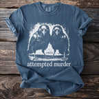 Blue t-shirt with white graphic of two crows and the text "attempted murder."