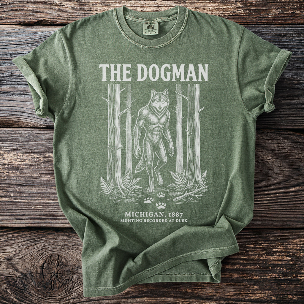 Green t-shirt with white print of "The Dogman," a werewolf, in a forest.