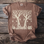 Brown t-shirt with a cream linocut print of a face between two trees.
