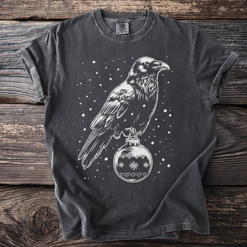 Dark t-shirt with white crow perched on a snowflake ornament design.