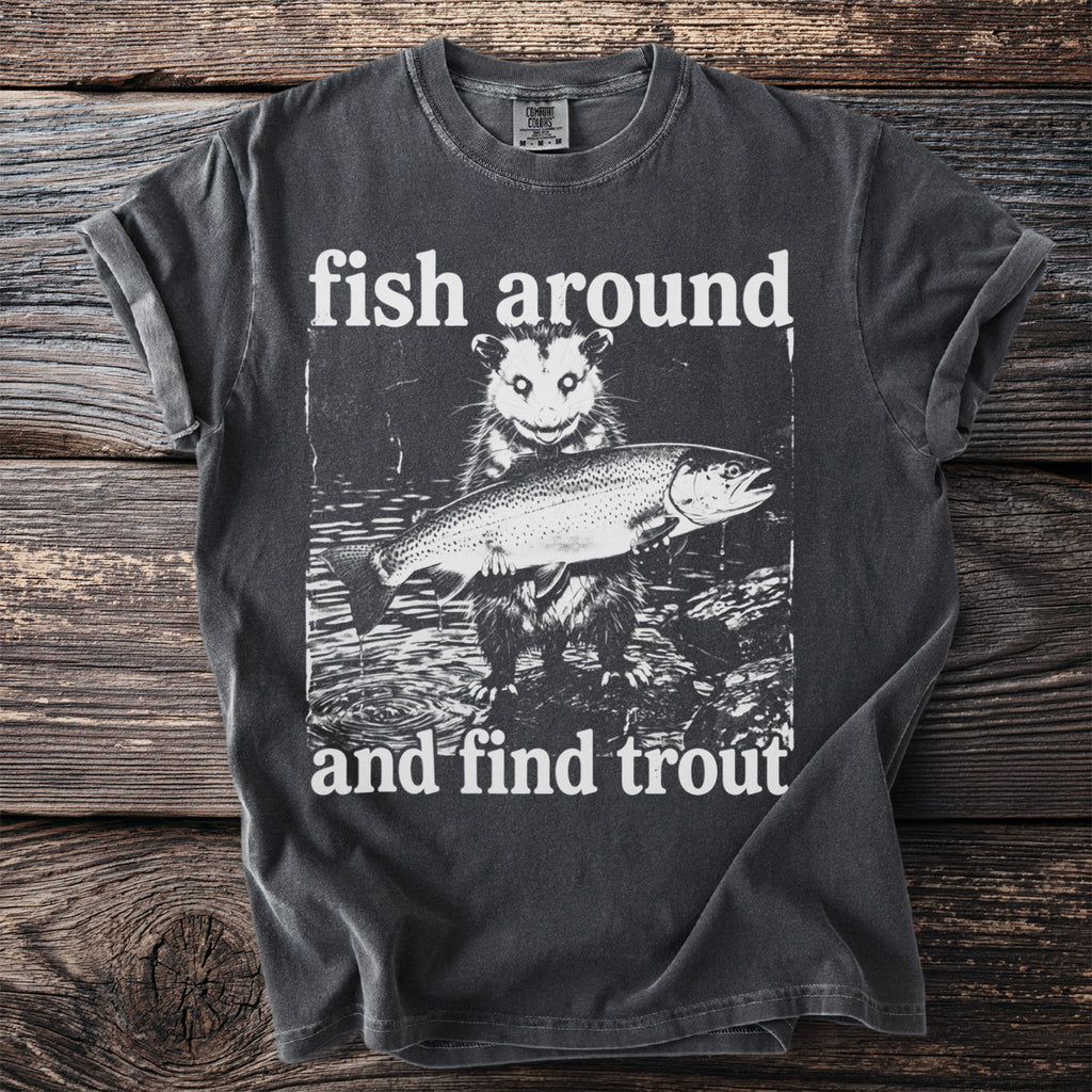 T-shirt graphic featuring an opossum holding a trout with text "fish around and find trout".