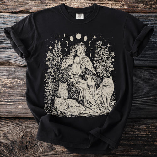 Illustration of a woman with cats, flowers, moon phases, and stars on a black t-shirt.