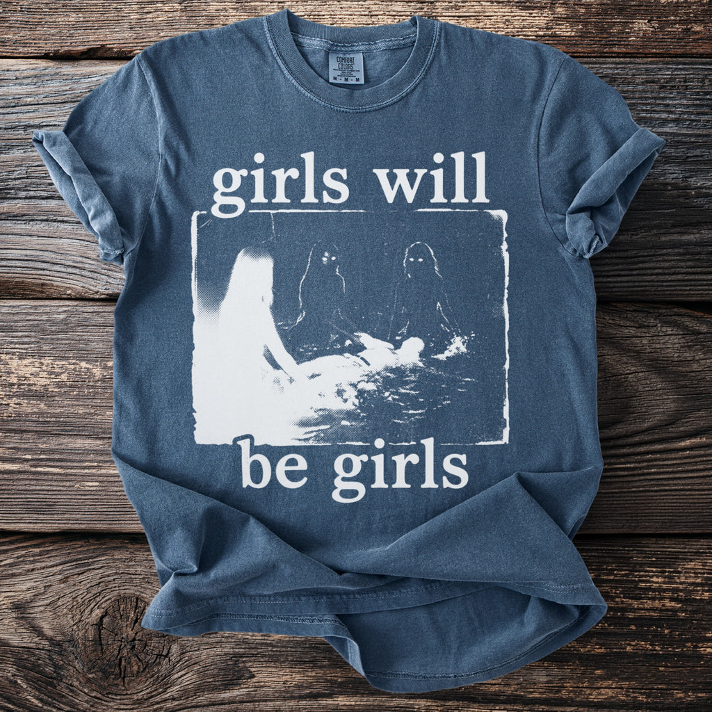 Blue t-shirt with white text "girls will be girls" and graphic of figures.