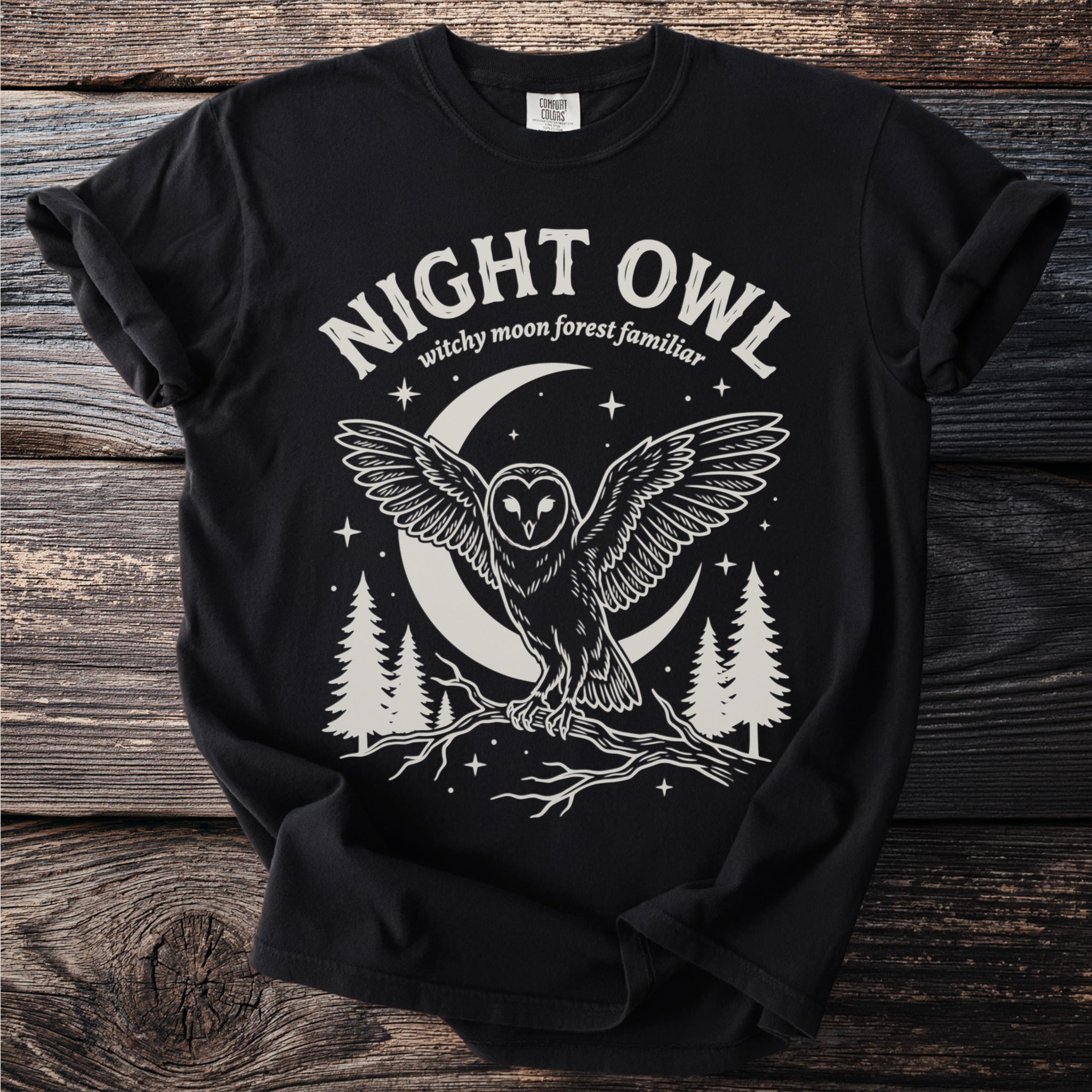 Black t-shirt with a creamy white graphic of an owl, crescent moon, trees, and "Night Owl" text.