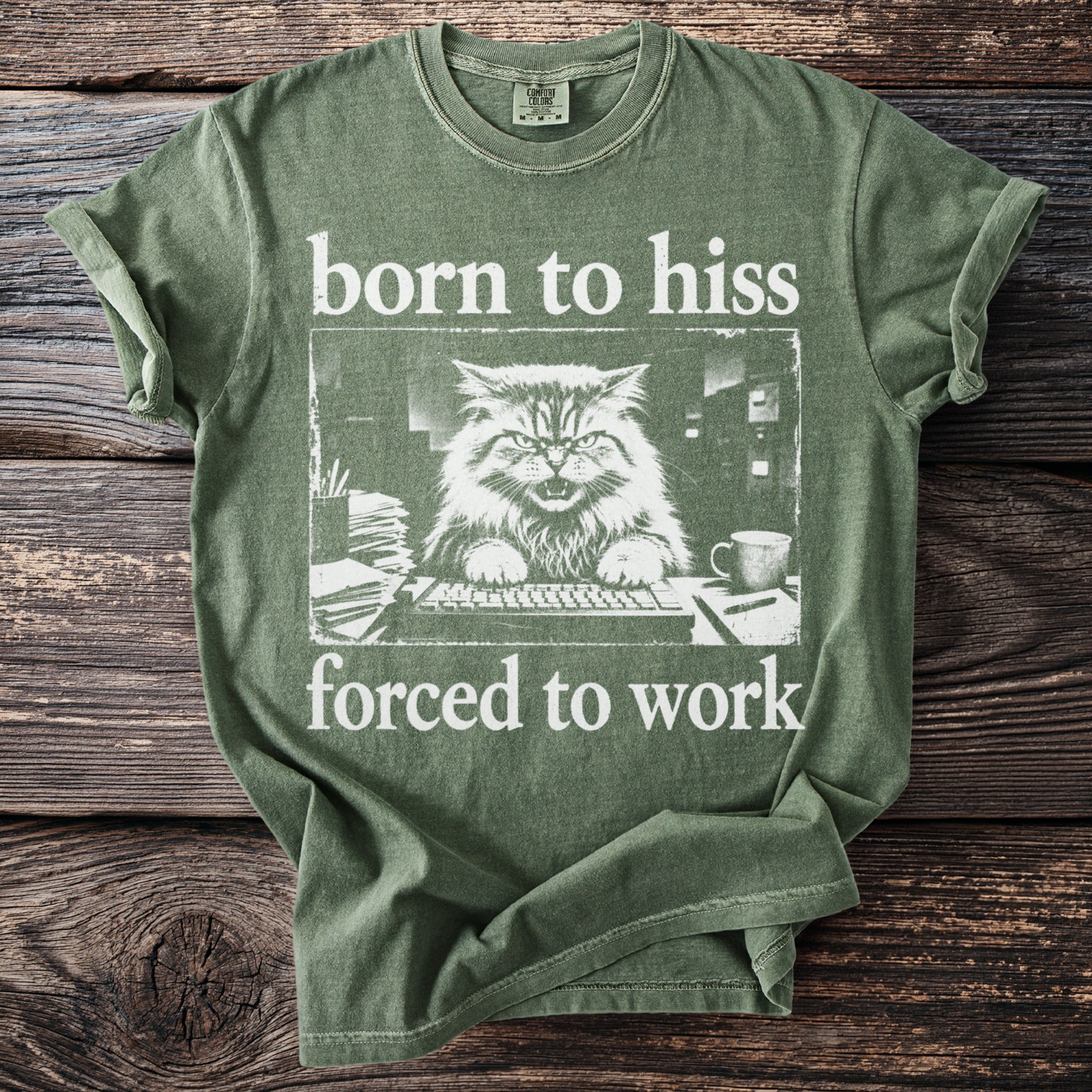 Green t-shirt with "born to hiss forced to work" text and a grumpy cat at a keyboard graphic.