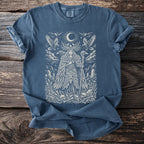 Blue t-shirt with a white illustration of a woman with antlers, birds, moon, and skulls.