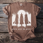 Brown t-shirt with graphic of three witches and the text "girls will be girls".