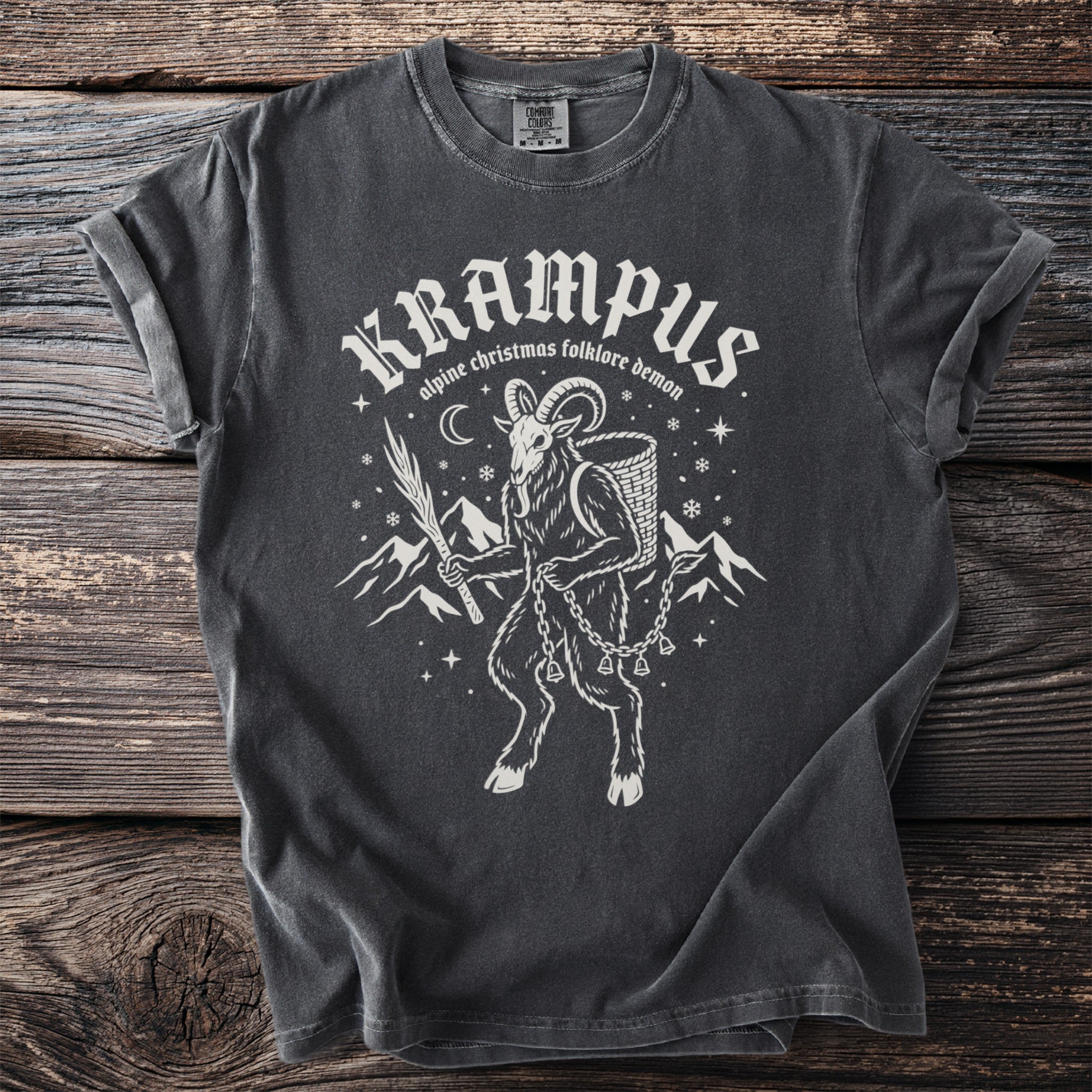 Dark gray t-shirt featuring "Krampus alpine Christmas folklore demon" and a goat-like figure.