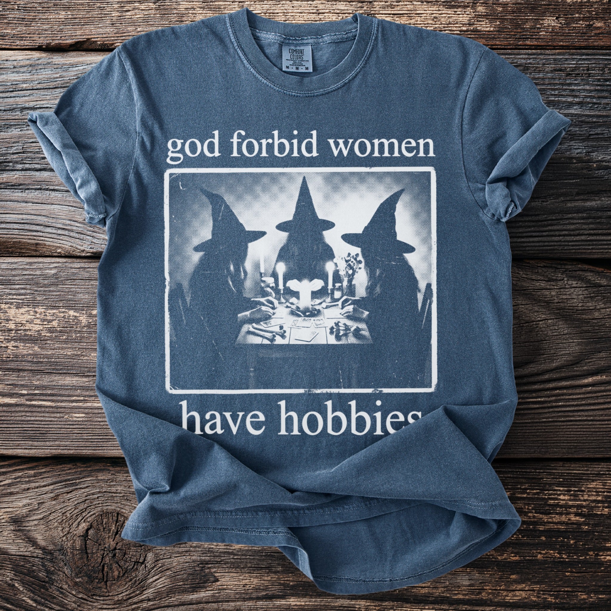Blue t-shirt with "god forbid women have hobbies" and witch graphic.