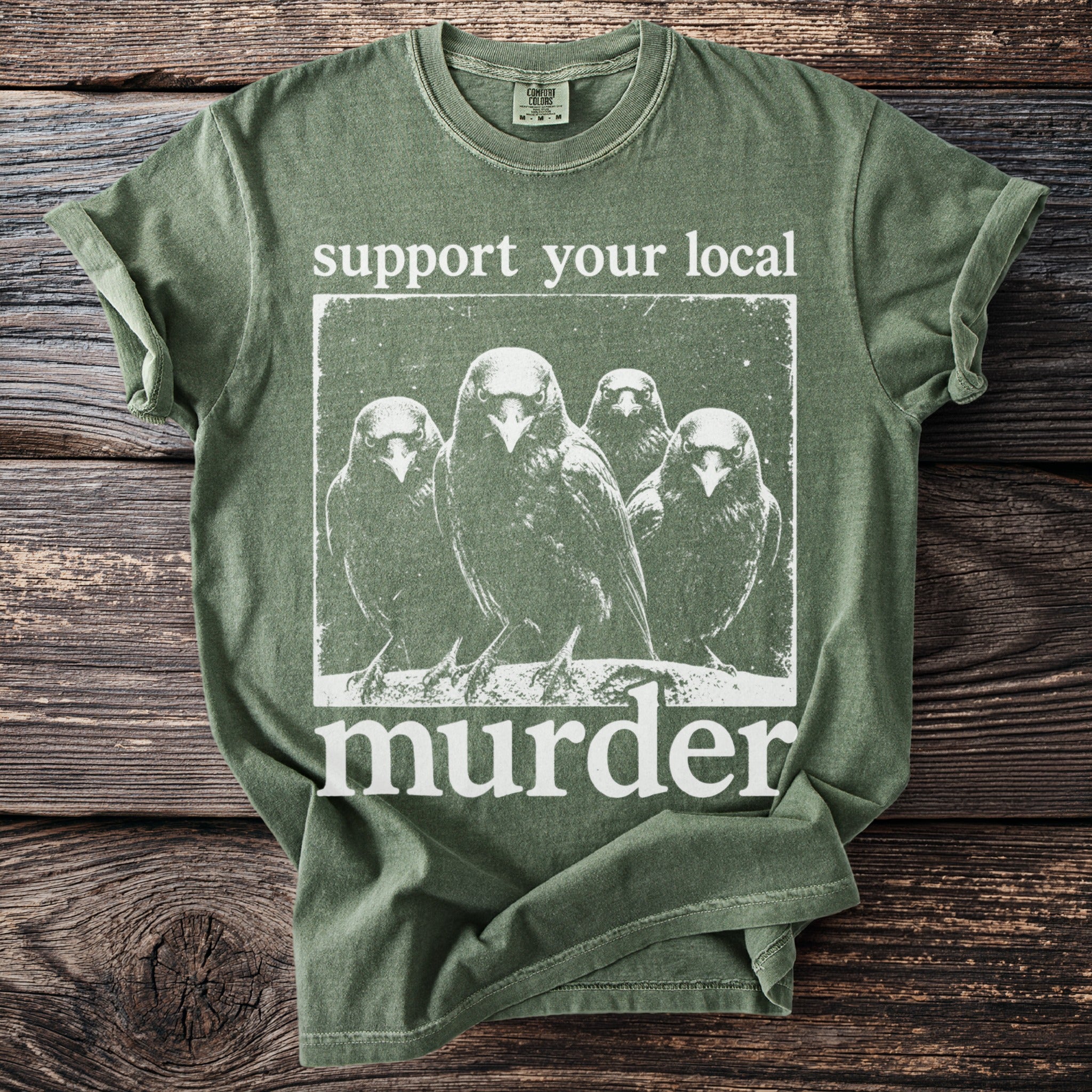 Green t-shirt with a graphic of four crows and text: "support your local murder."