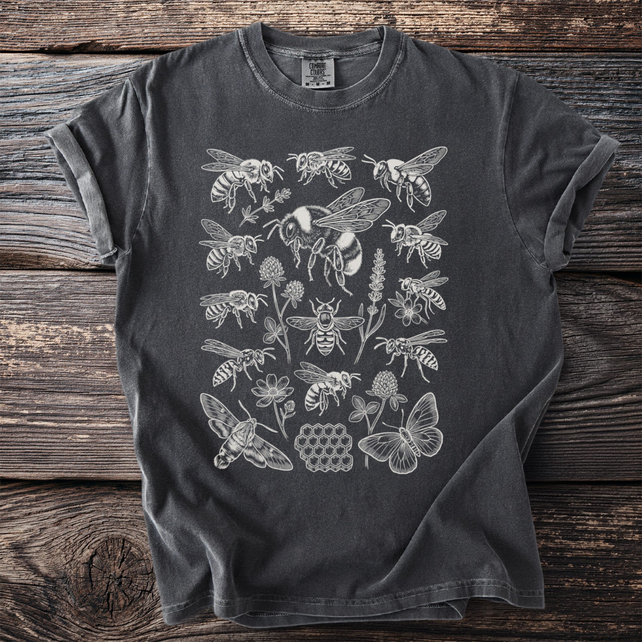 Charcoal t-shirt with white line art of bees, butterflies, flowers, and honeycomb.