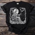 Black t-shirt with a white graphic of a woman spinning constellations by a full moon.
