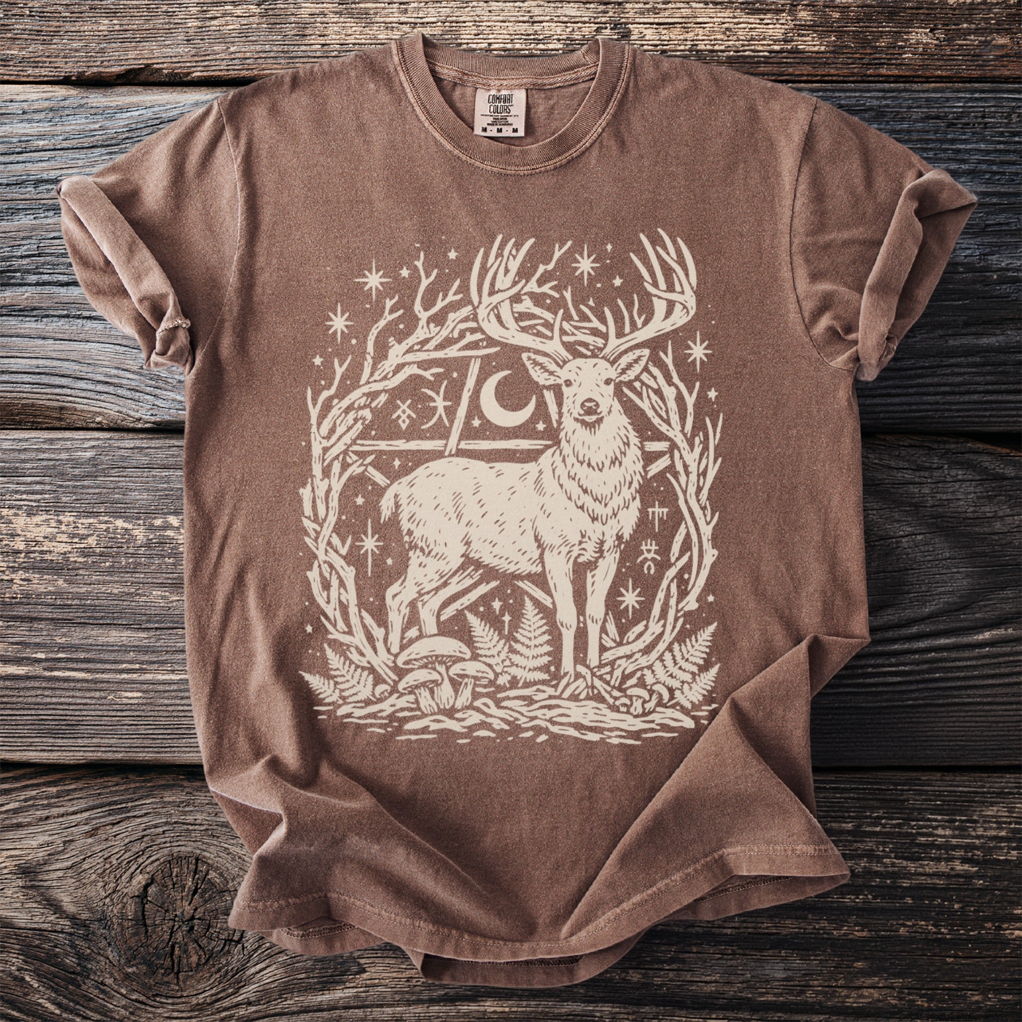 Brown t-shirt with white mystical stag, moon, stars, and nature symbols graphic.