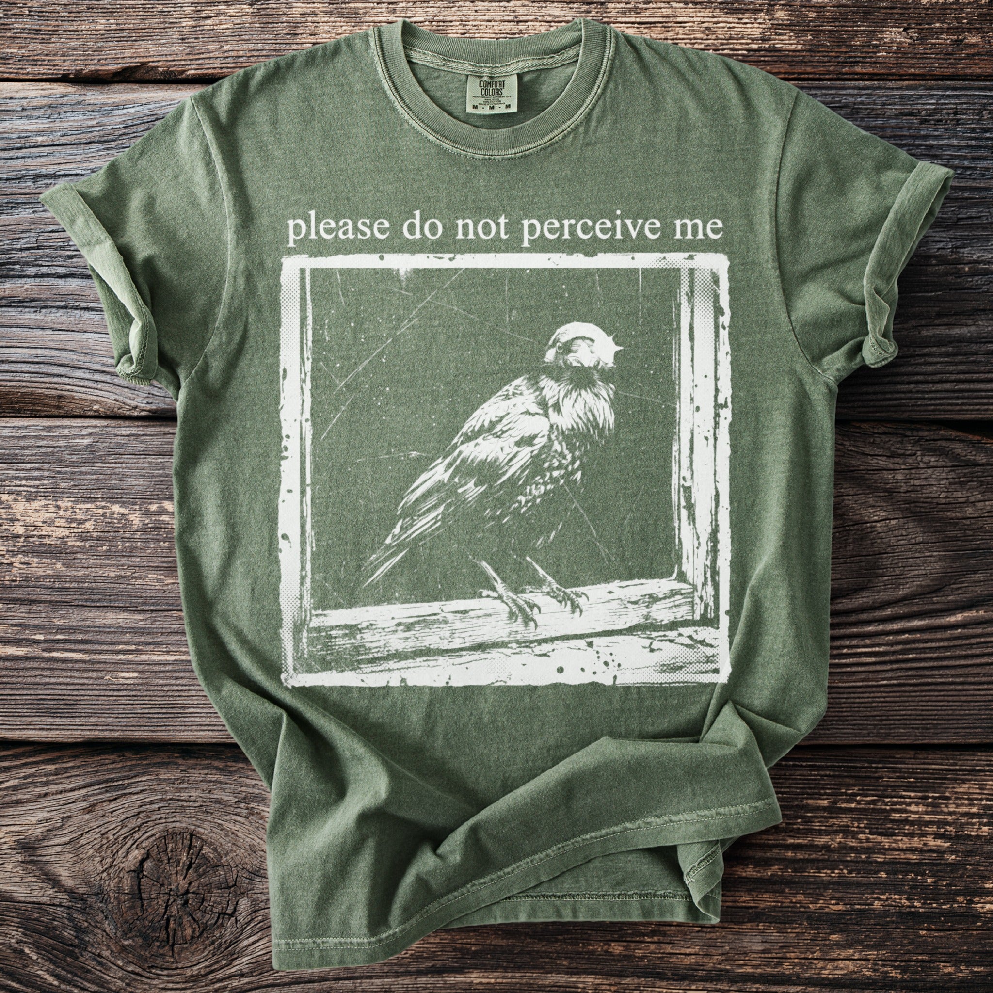 Green t-shirt with white graphic and text: "please do not perceive me".