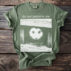 Green t-shirt with a white graphic of an opossum's face and text "do not perceive me".