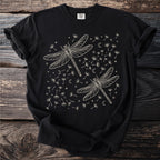 Black t-shirt with light cream dragonflies, dandelions, moons, and stars graphic.