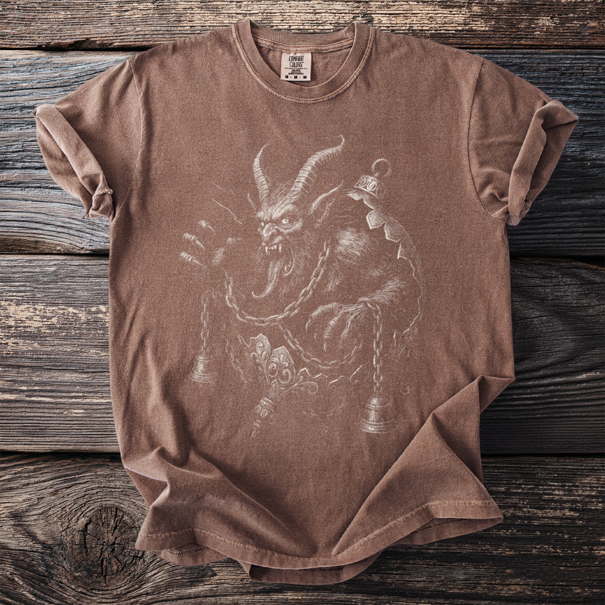 Brown t-shirt with a detailed white line drawing of Krampus and bells.