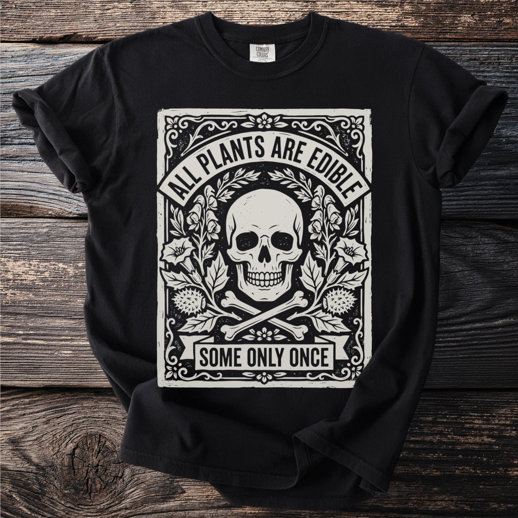 Black t-shirt with skull, bones, floral design, and text "ALL PLANTS ARE EDIBLE SOME ONLY ONCE".