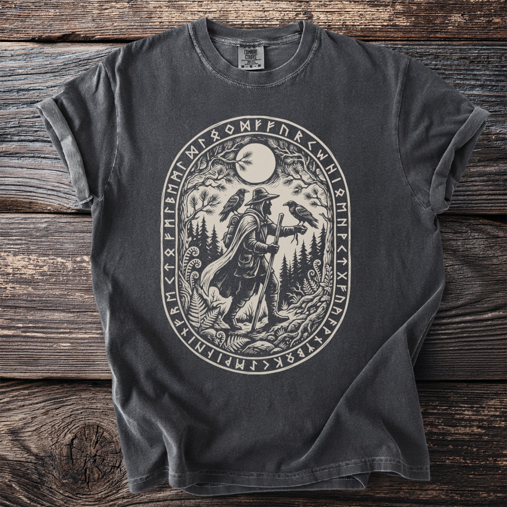 T-shirt with oval print of a traveler with two ravens under a moon, surrounded by runes.