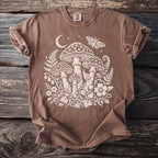 Brown t-shirt with white cream-colored mushroom, moth, and floral graphic.