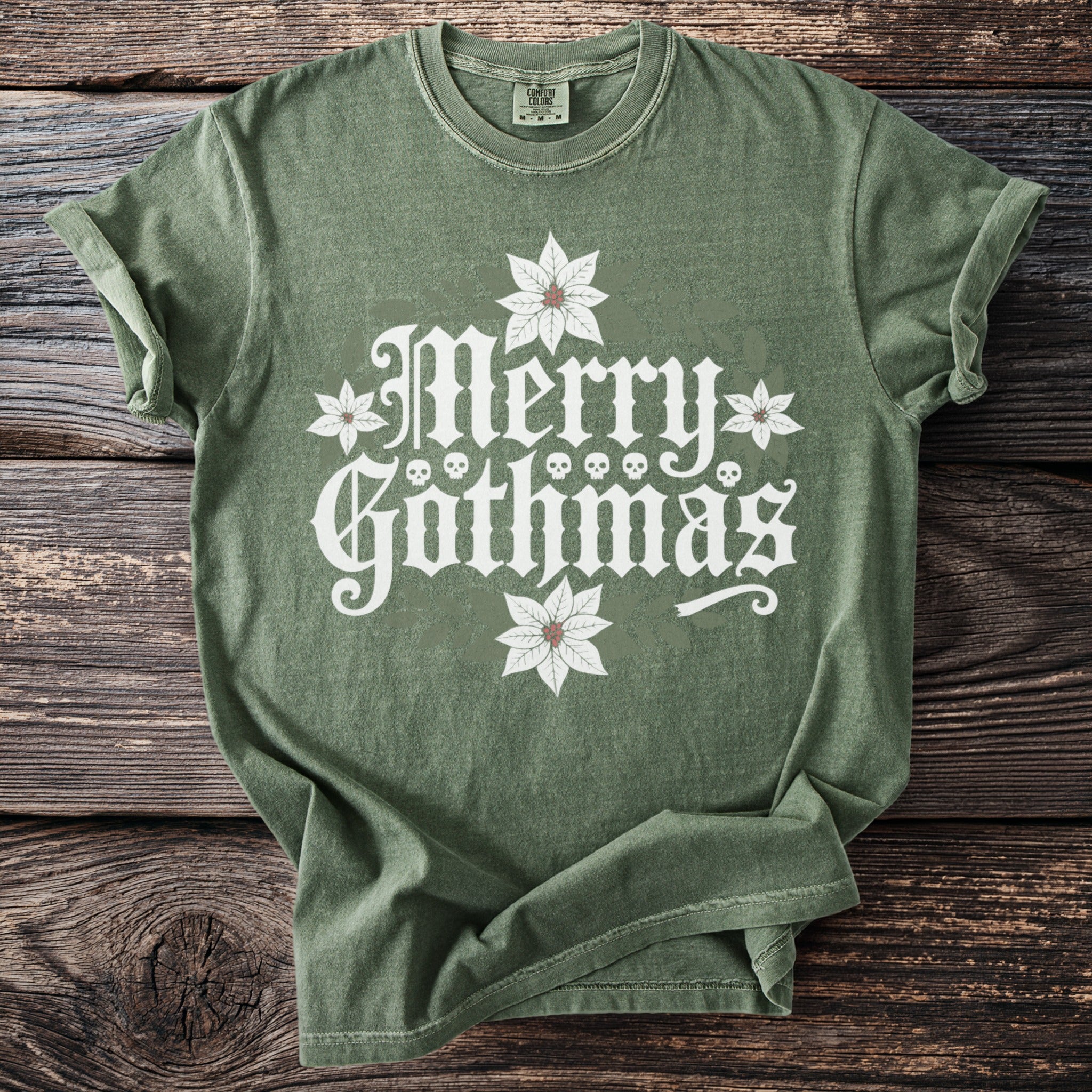 Green t-shirt with white "Merry Gothmas" text, skulls, and poinsettias.