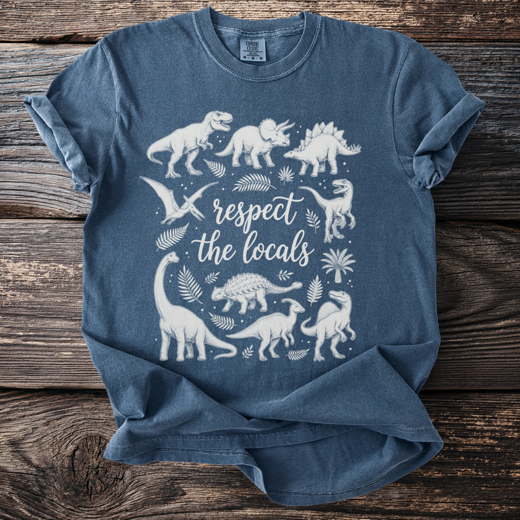 Blue t-shirt with white illustrations of dinosaurs and the text "respect the locals".