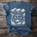 Blue t-shirt with white illustrations of dinosaurs and the text "respect the locals".