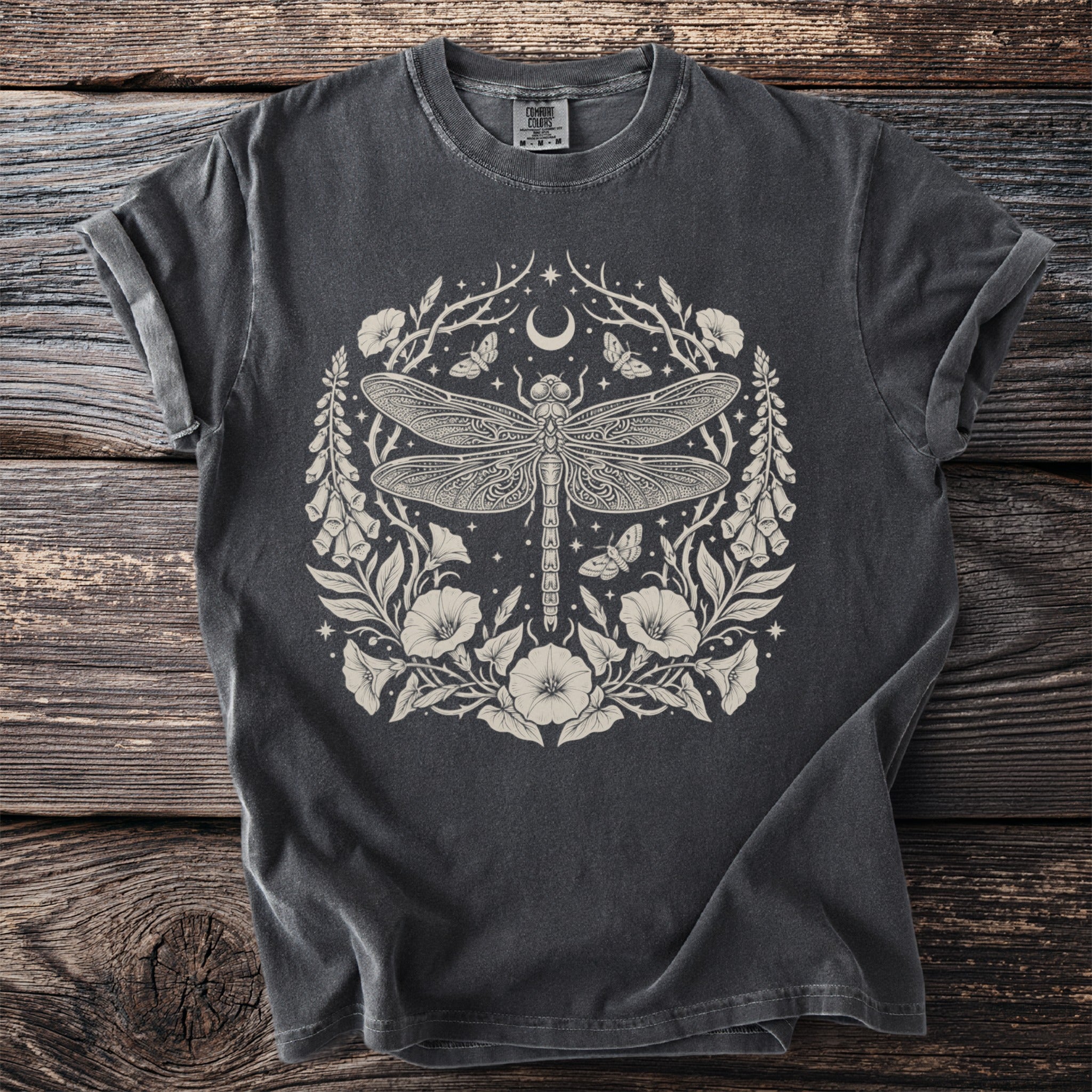 Dark grey t-shirt with a cream-colored circular dragonfly, moon, and floral design.