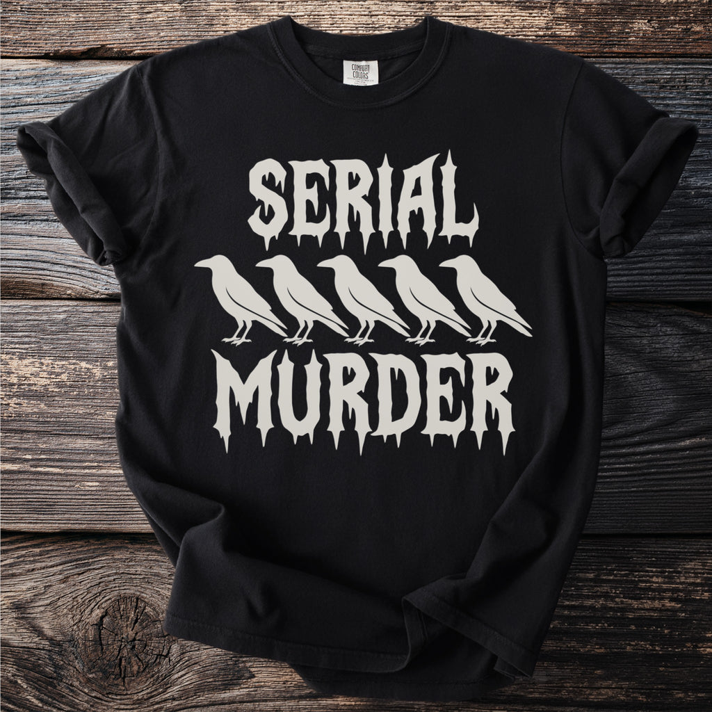 Black t-shirt with white text "SERIAL MURDER" and five crow silhouettes.