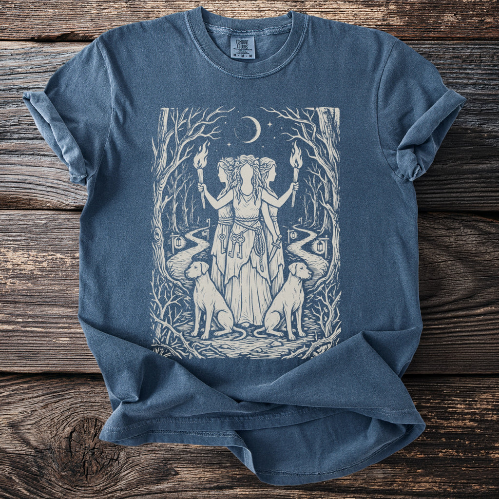 Blue t-shirt with three figures, two dogs, torches, and keys in a forest scene.