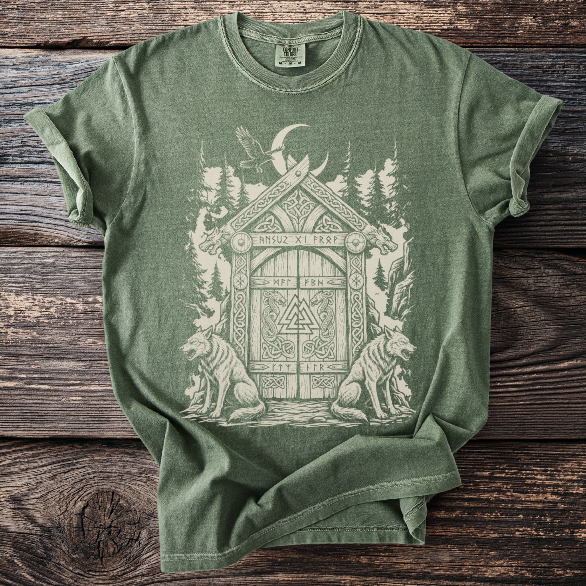 Green t-shirt with Viking-inspired distressed graphic of a gate, wolves, and raven.