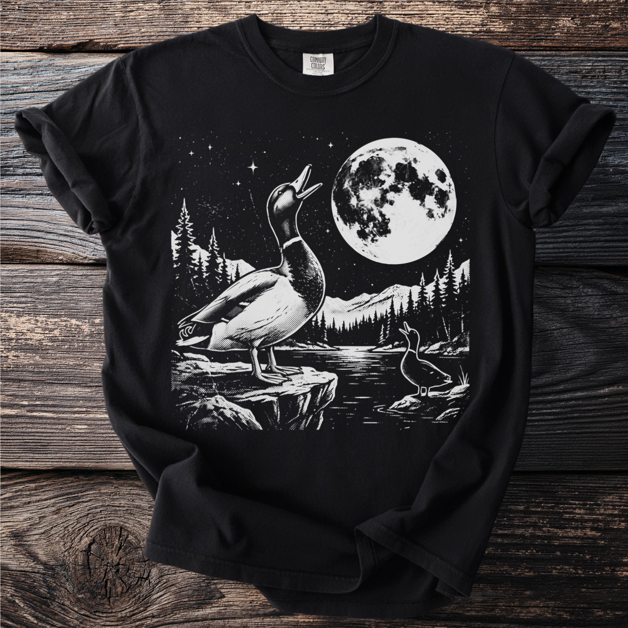 Black t-shirt with graphic of ducks by a moonlit lake with forest and mountains.