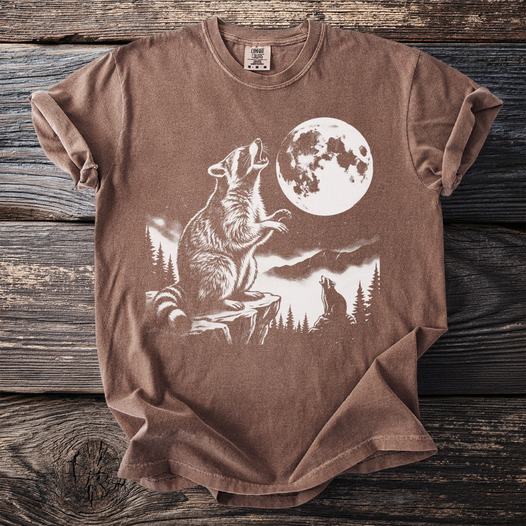 Brown t-shirt with graphic of raccoons howling at a full moon.
