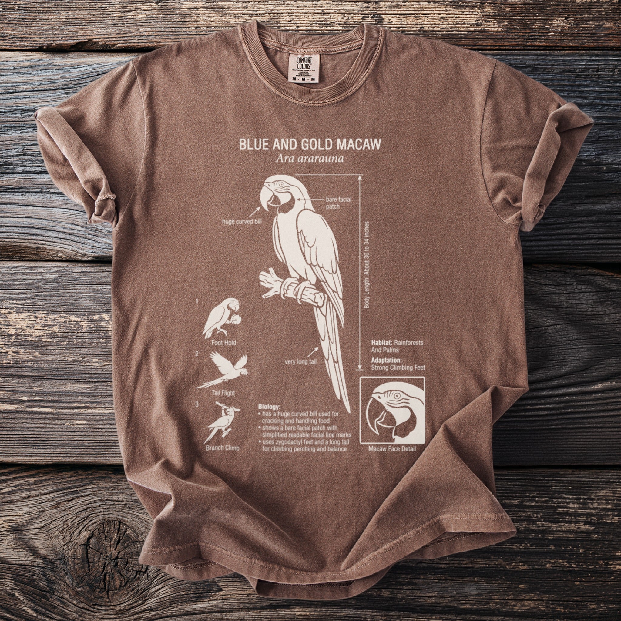 Brown t-shirt with white illustration of a Blue and Gold Macaw and explanatory text.