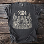 Dark t-shirt with cream graphic of triple moon, goddesses, and stags.