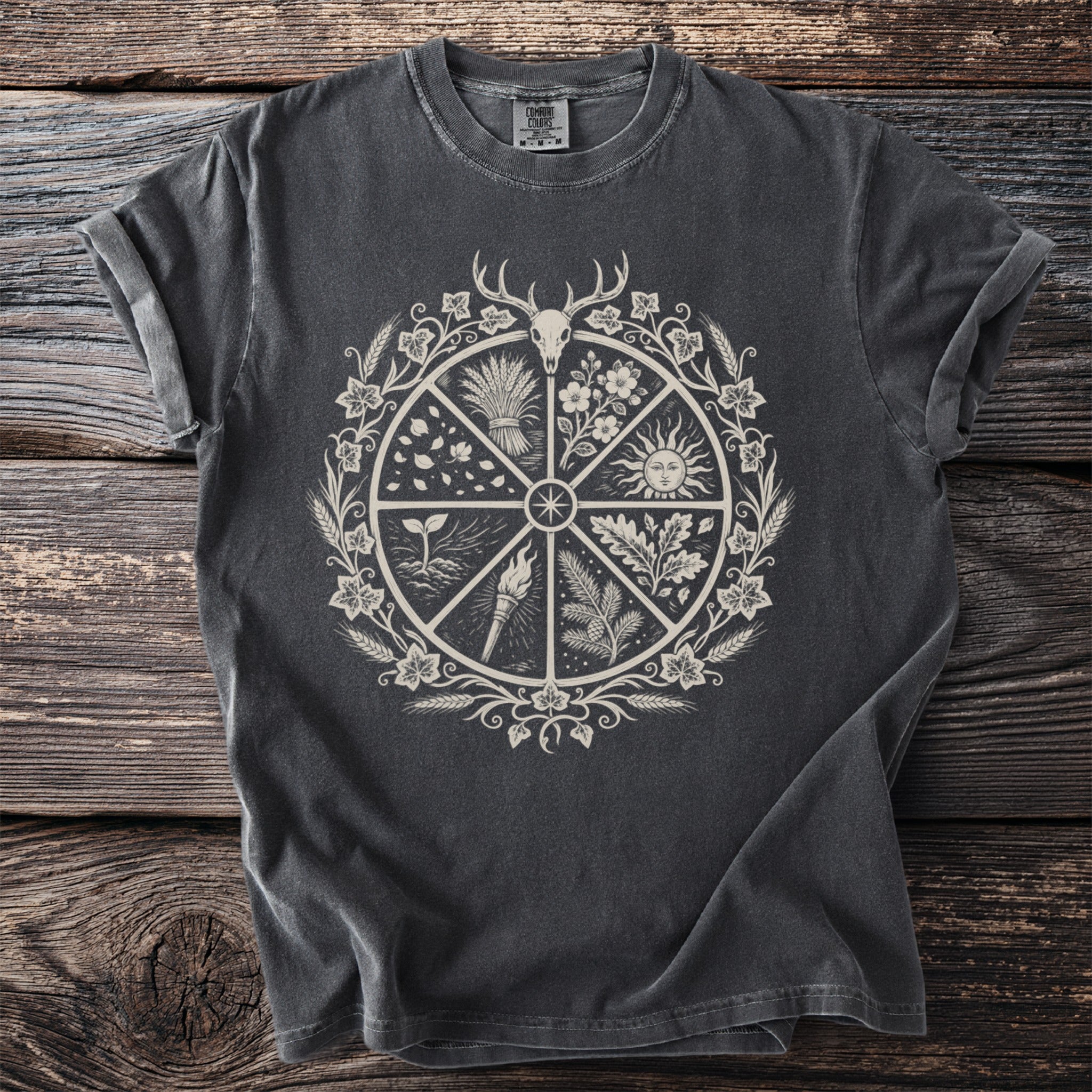 Dark gray t-shirt with a central circular design featuring a deer skull, sun, and seasonal imagery.