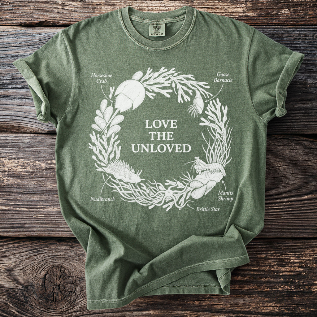 Green t-shirt with white illustration of sea creatures and text "Love the Unloved."