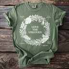 Green t-shirt with white illustration of sea creatures and text "Love the Unloved."