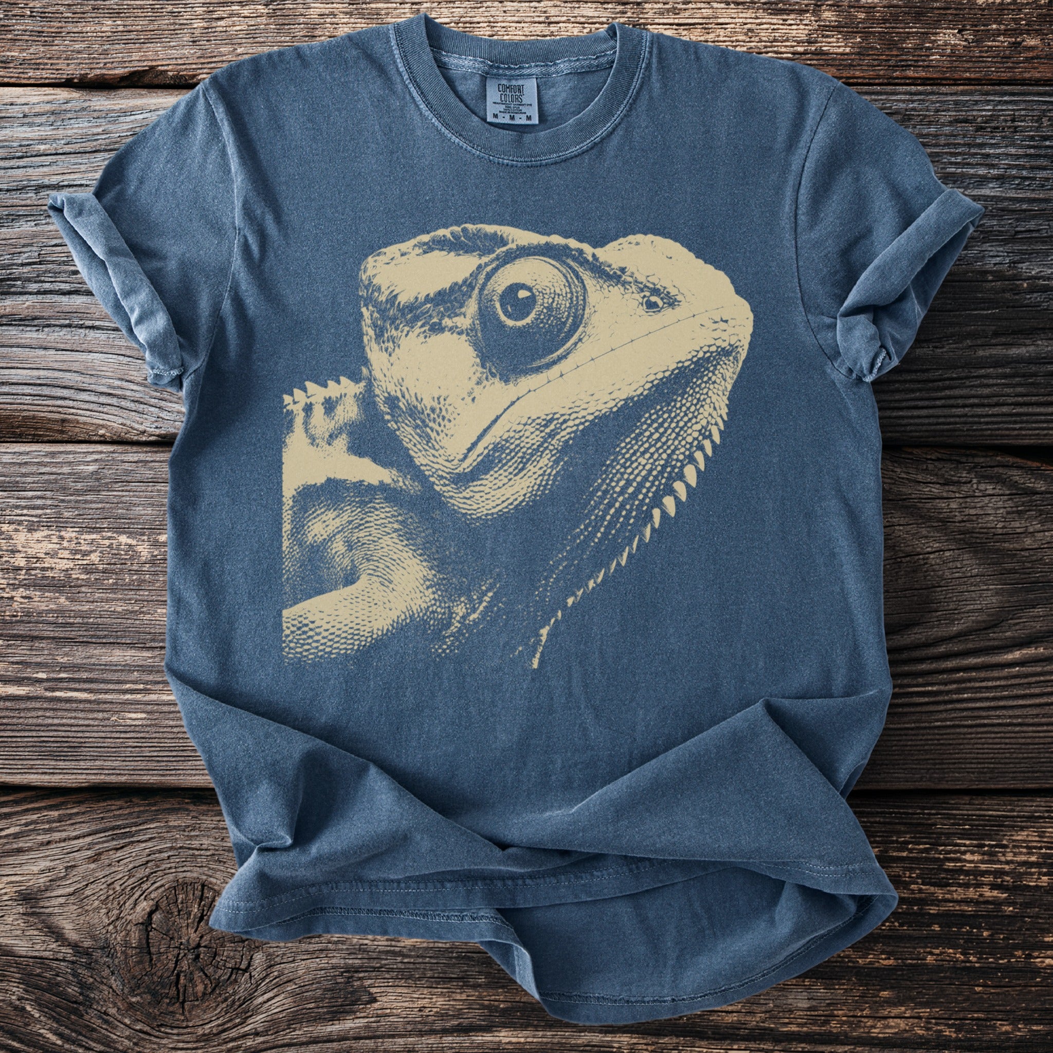 Blue t-shirt with a tan distressed print of a lizard's head.