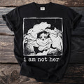 Black t-shirt graphic of dog peeking from laundry, with text "i am not her".