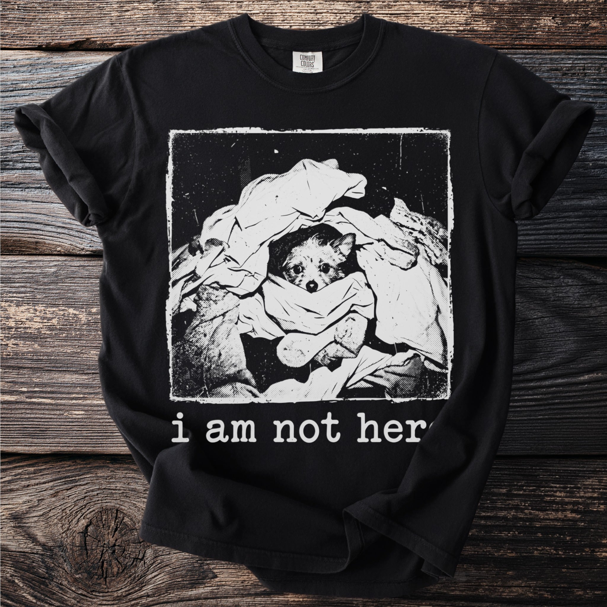 Black t-shirt graphic of dog peeking from laundry, with text "i am not her".