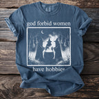 T-shirt with witches around a cauldron and text "god forbid women have hobbies."