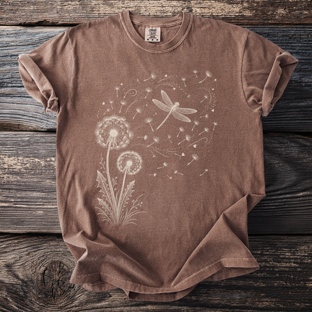 Brown t-shirt with a white line drawing of dandelions and a dragonfly.