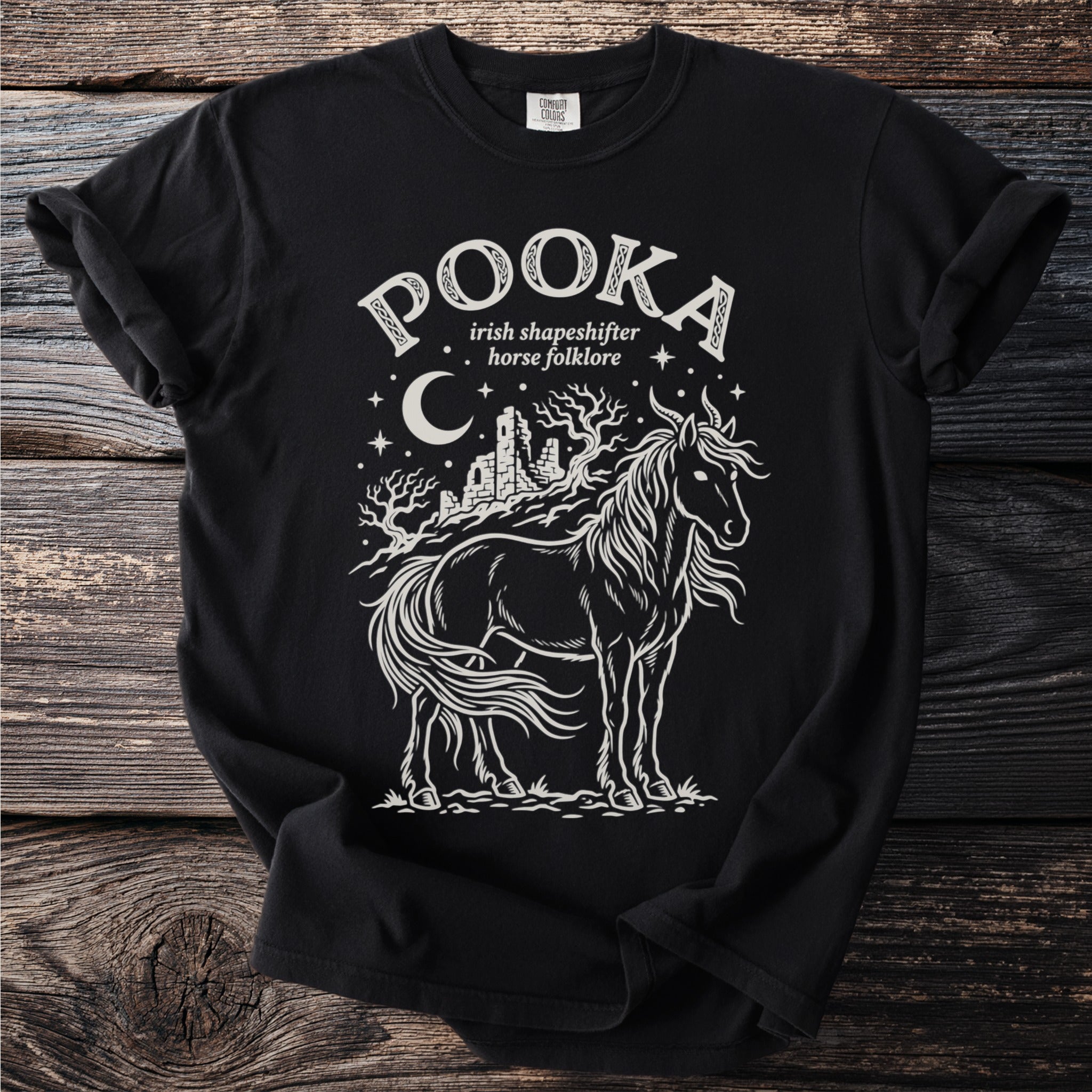 Black t-shirt with white graphic of a horse, castle ruins, and moon, reading "Pooka Irish shapeshifter horse folklore".