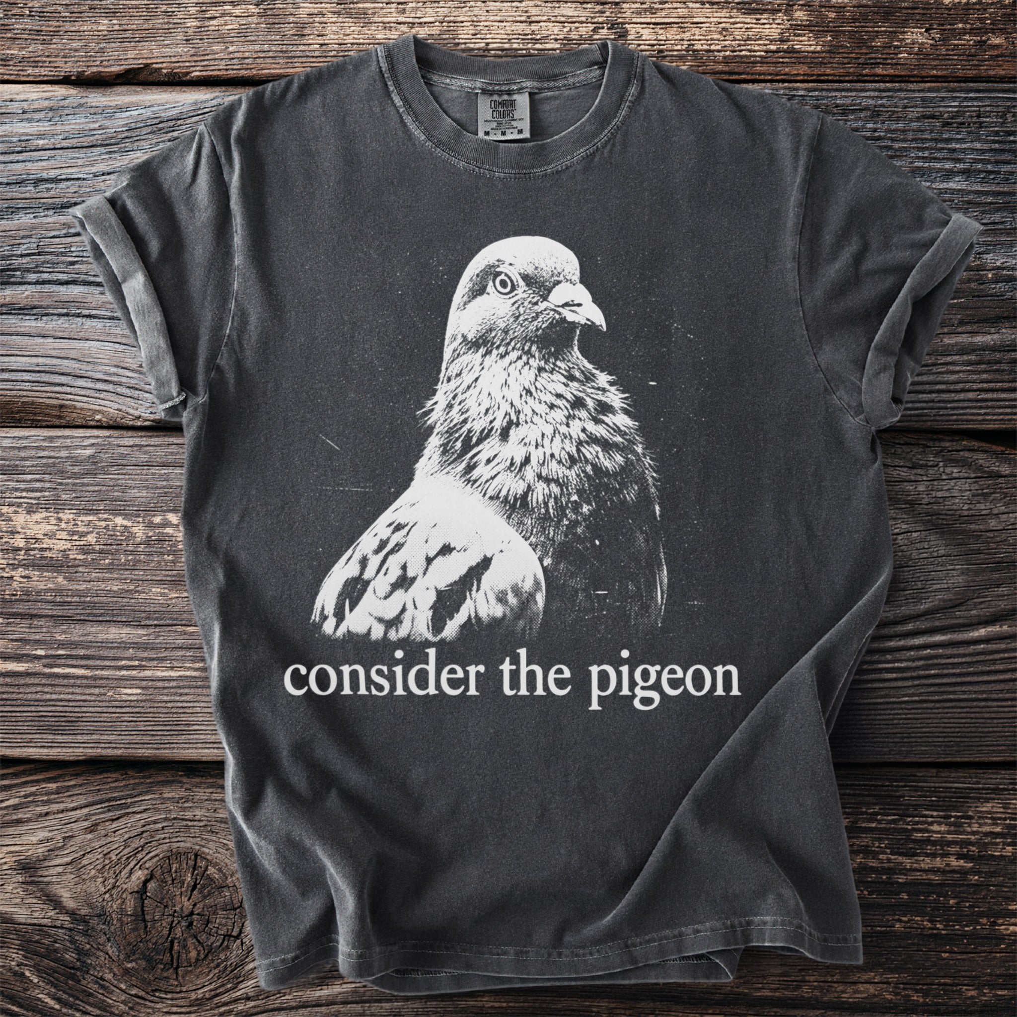 Dark grey t-shirt with white pigeon graphic and "consider the pigeon" text.