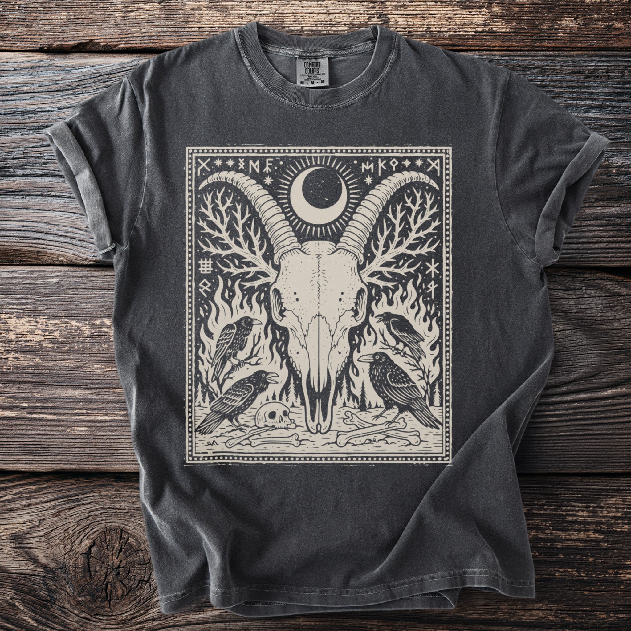 Dark gray t-shirt with a black and beige print of a goat skull, ravens, and runes.