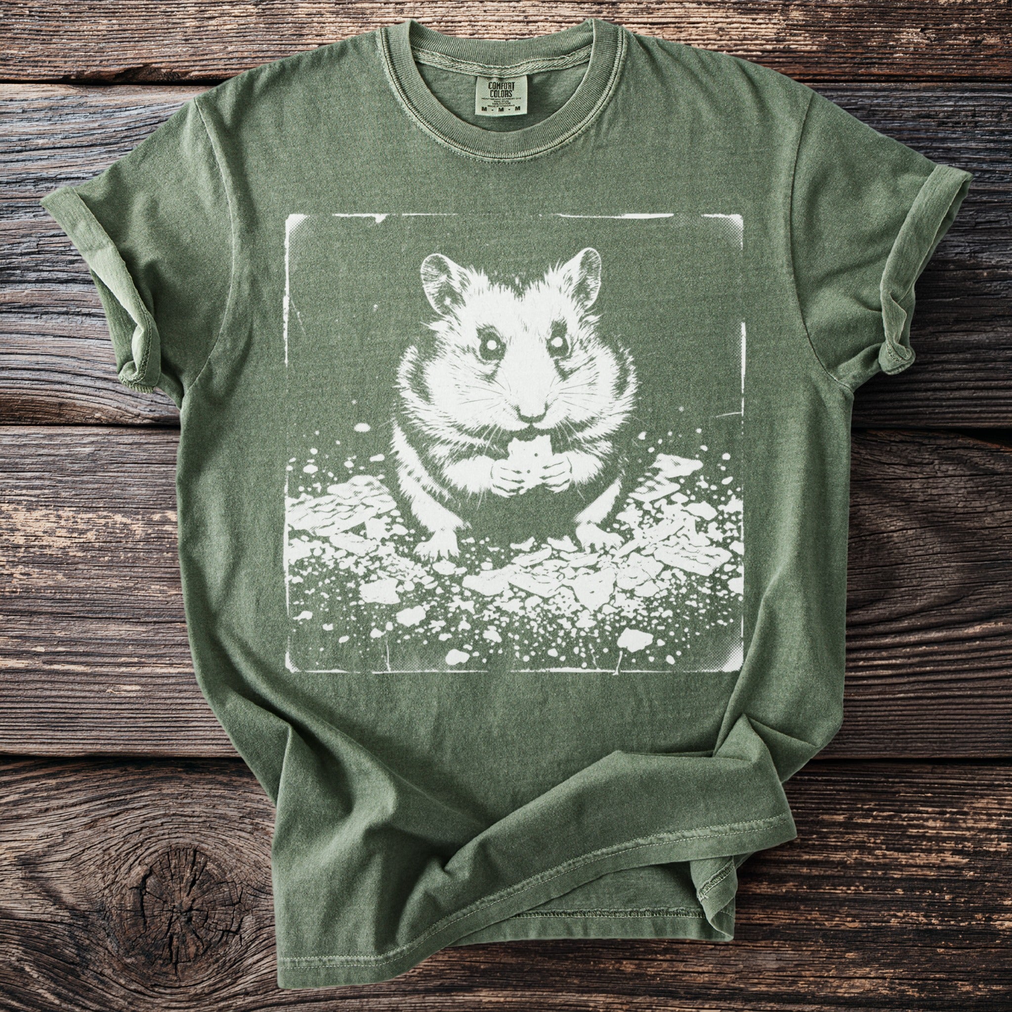 Green t-shirt with a white graphic of a hamster holding a treat.