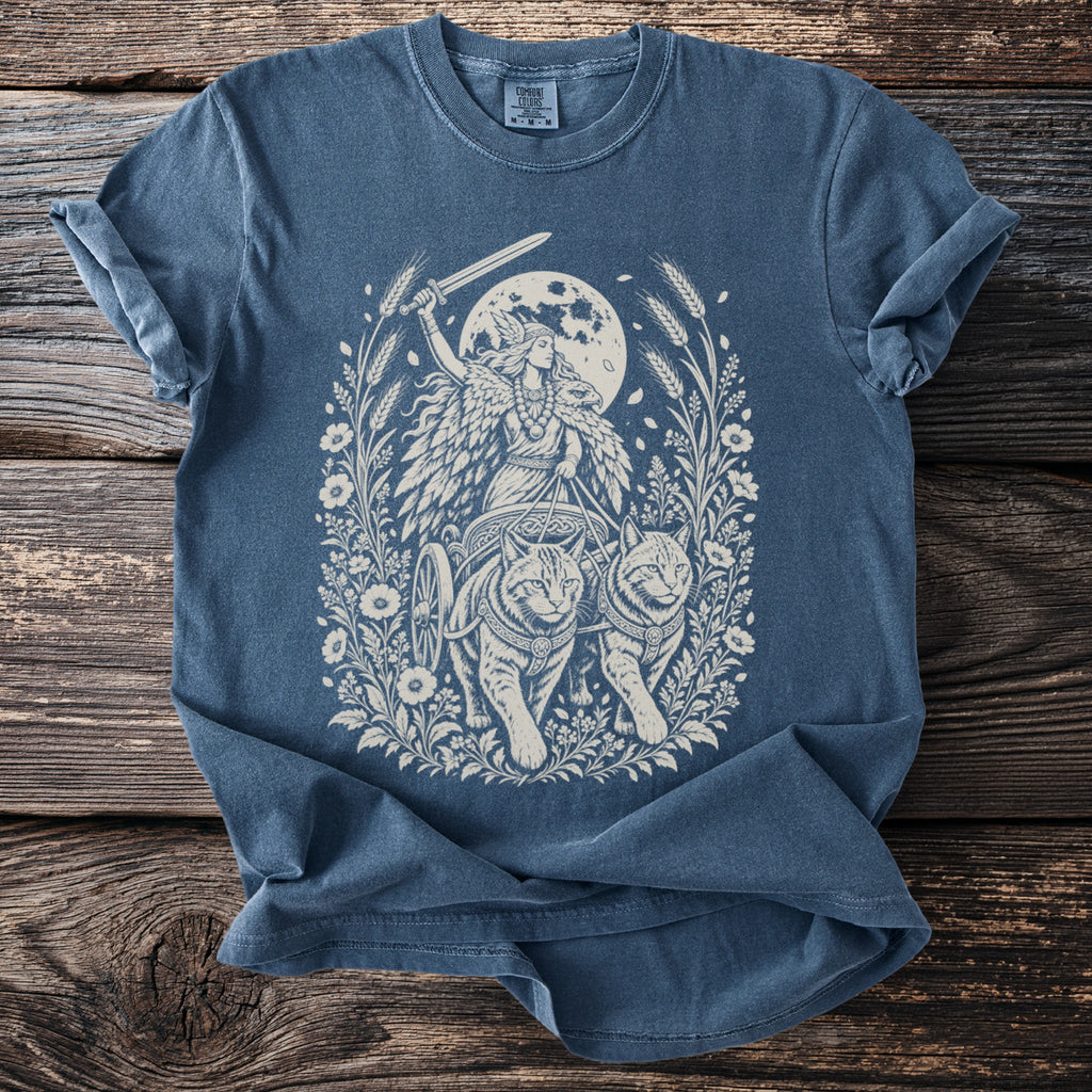 Valkyrie in chariot pulled by cats, sword raised, under full moon.