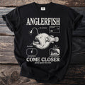 Black t-shirt graphic with "ANGLERFISH" text, illustrative diagrams, and "COME CLOSER" text.