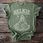 Green t-shirt with white "Selkie Scottish Seal Folk Legend" graphic.